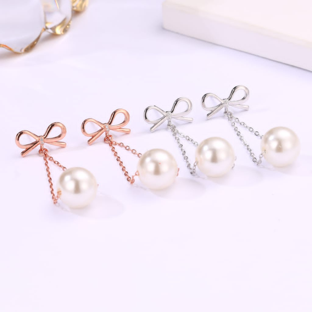 Bow Pearl Earrings: Chic design with a lustrous pearl on a sterling silver base, featuring rose gold and silver plating.