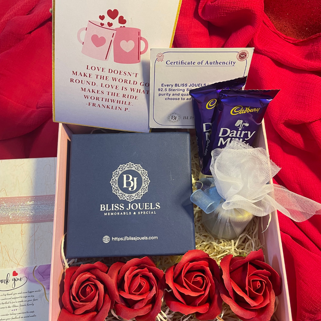 Valentine Hamper featuring a box with roses, a handwritten note, two chocolates, and a scented candle, perfect for expressing love on Valentine's Day.