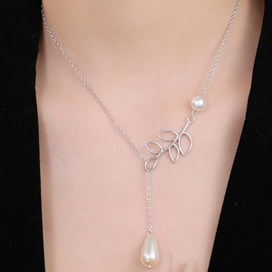 Close-up of the Pearl N Leaf necklace featuring lustrous pearls intertwined with delicate leaf motifs on a person's neck.