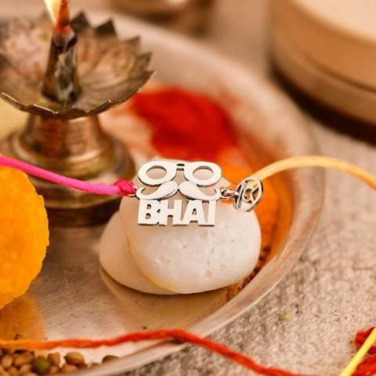 Close-up of Bliss Jouels Modern ‘BHAI’ Rakhi Bracelet with bold metallic letters on a white backdrop and vibrant multi-colored thread, perfect for Raksha Bandhan.